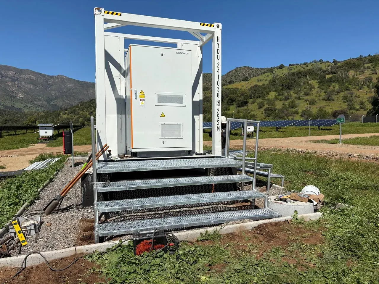 Escalera y plataforma metálica de acceso a un equipo industrial instalado en terreno, fabricada por IKKIO SERVICES